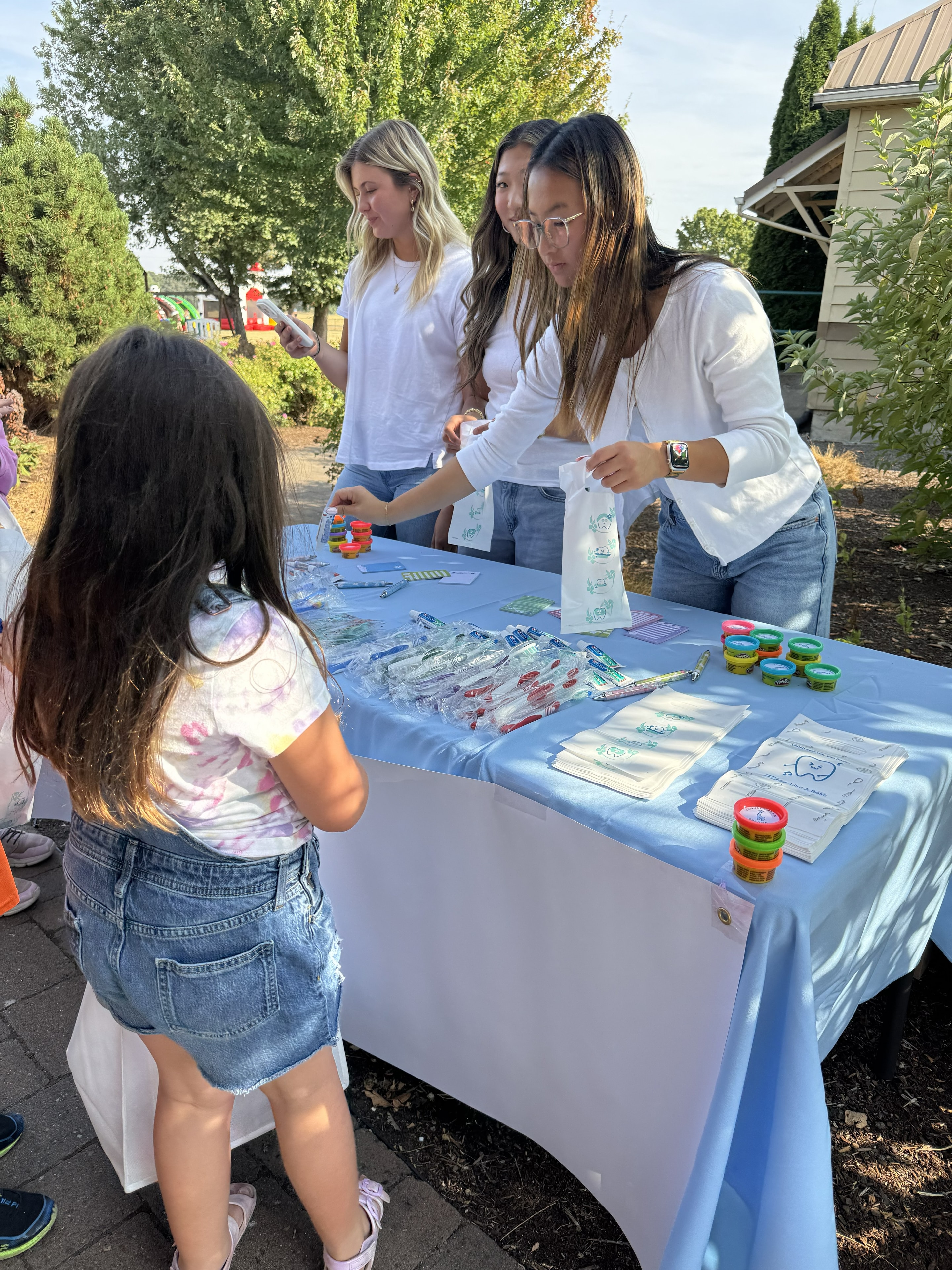 Dental hygiene table with volunteers and kids