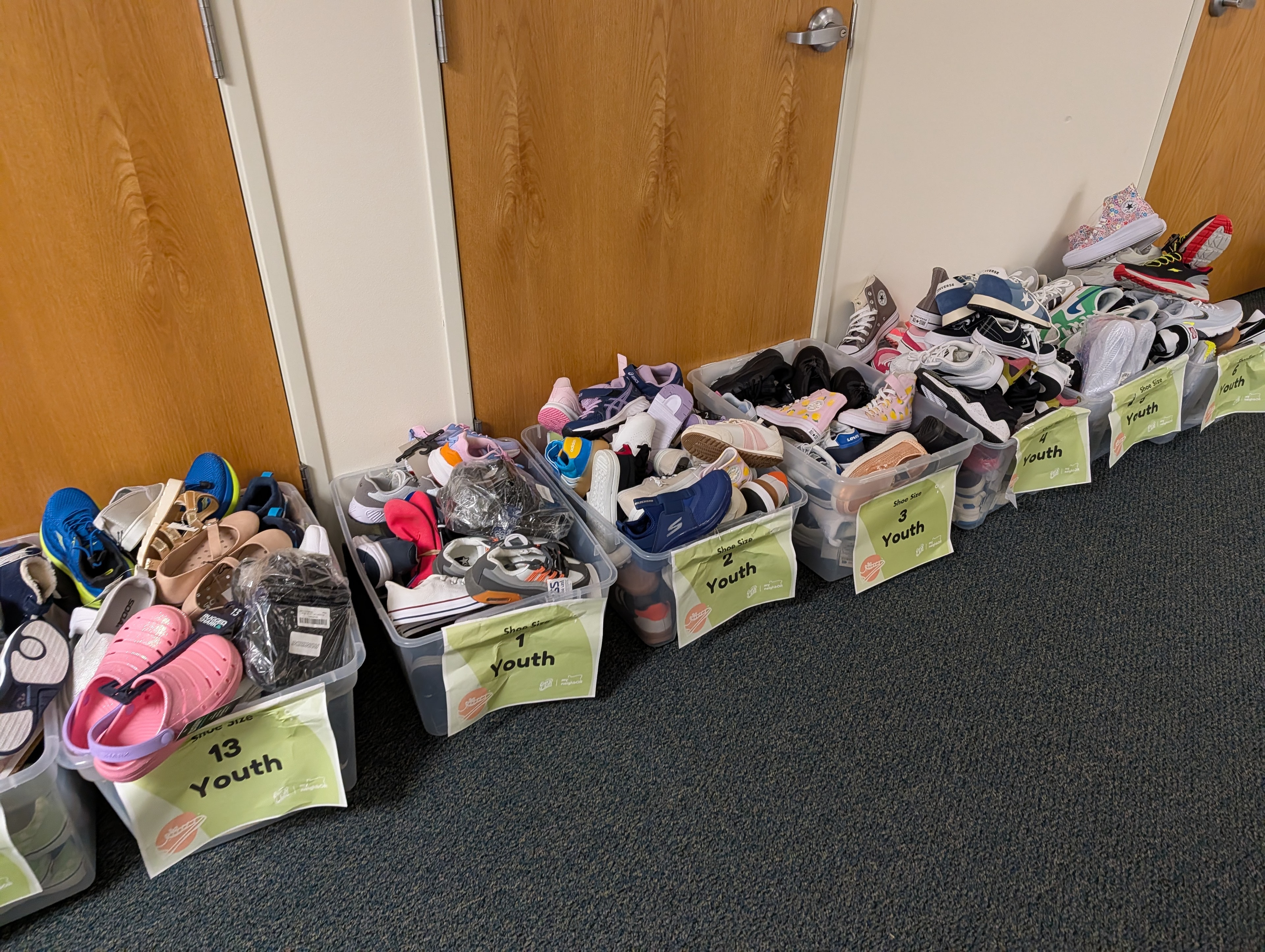 Bins of donated youth shoes sorted by size